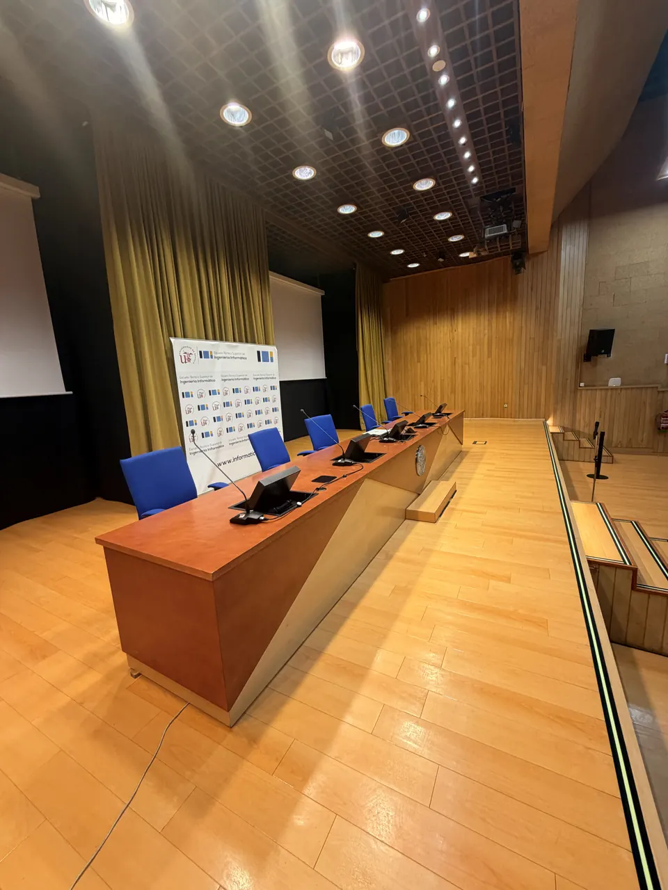 The presidential table on the stage, with microphones and screens