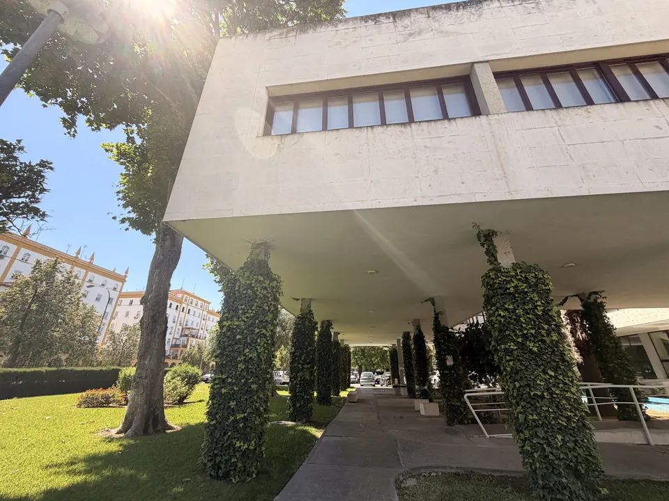Covered porch on ivy-clad pillars, opening onto a lawn